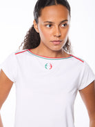 Woman wearing a white t-shirt with red and green accent details.