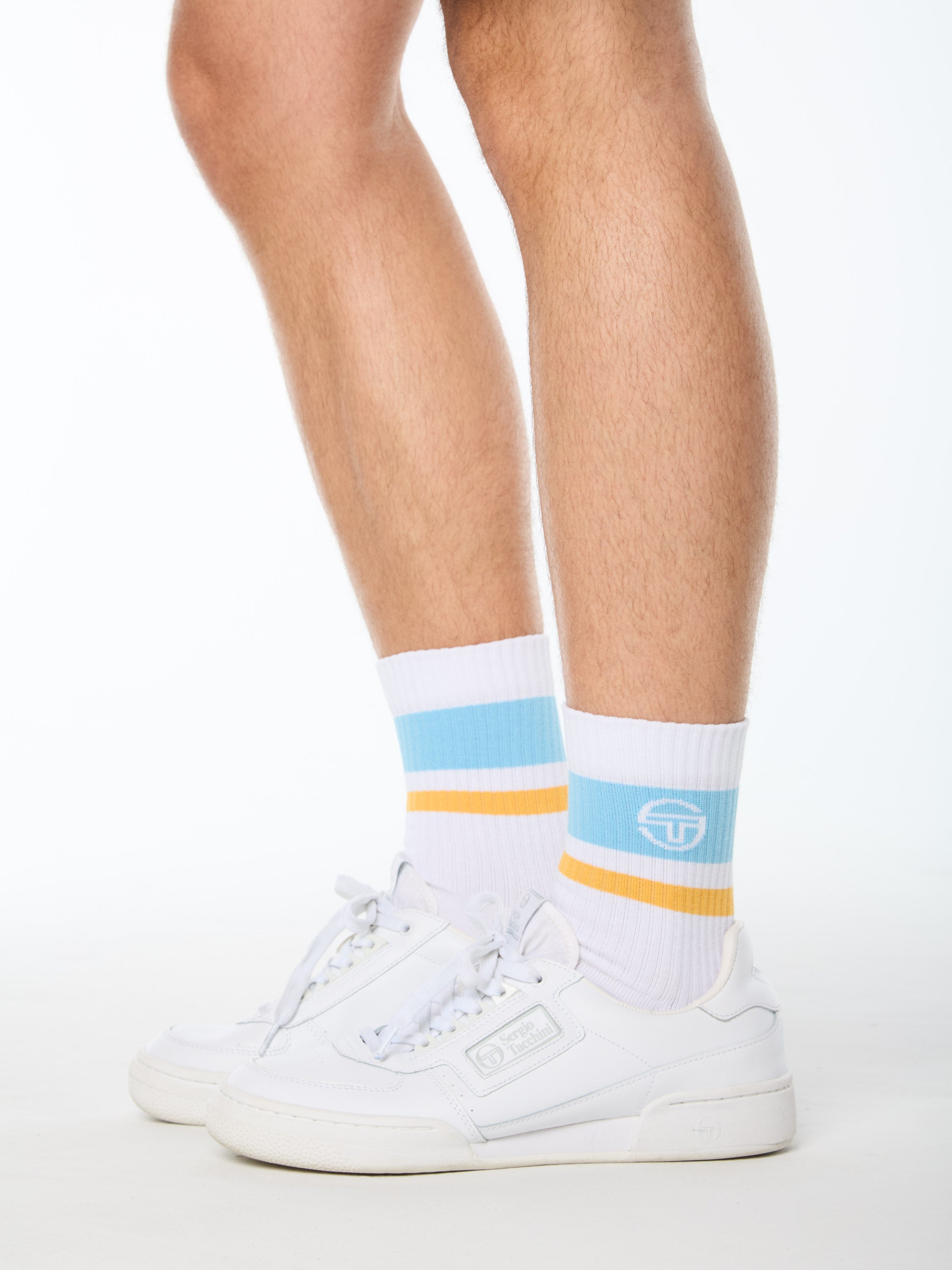 Man wearing white socks with baby blue and yellow stripes.