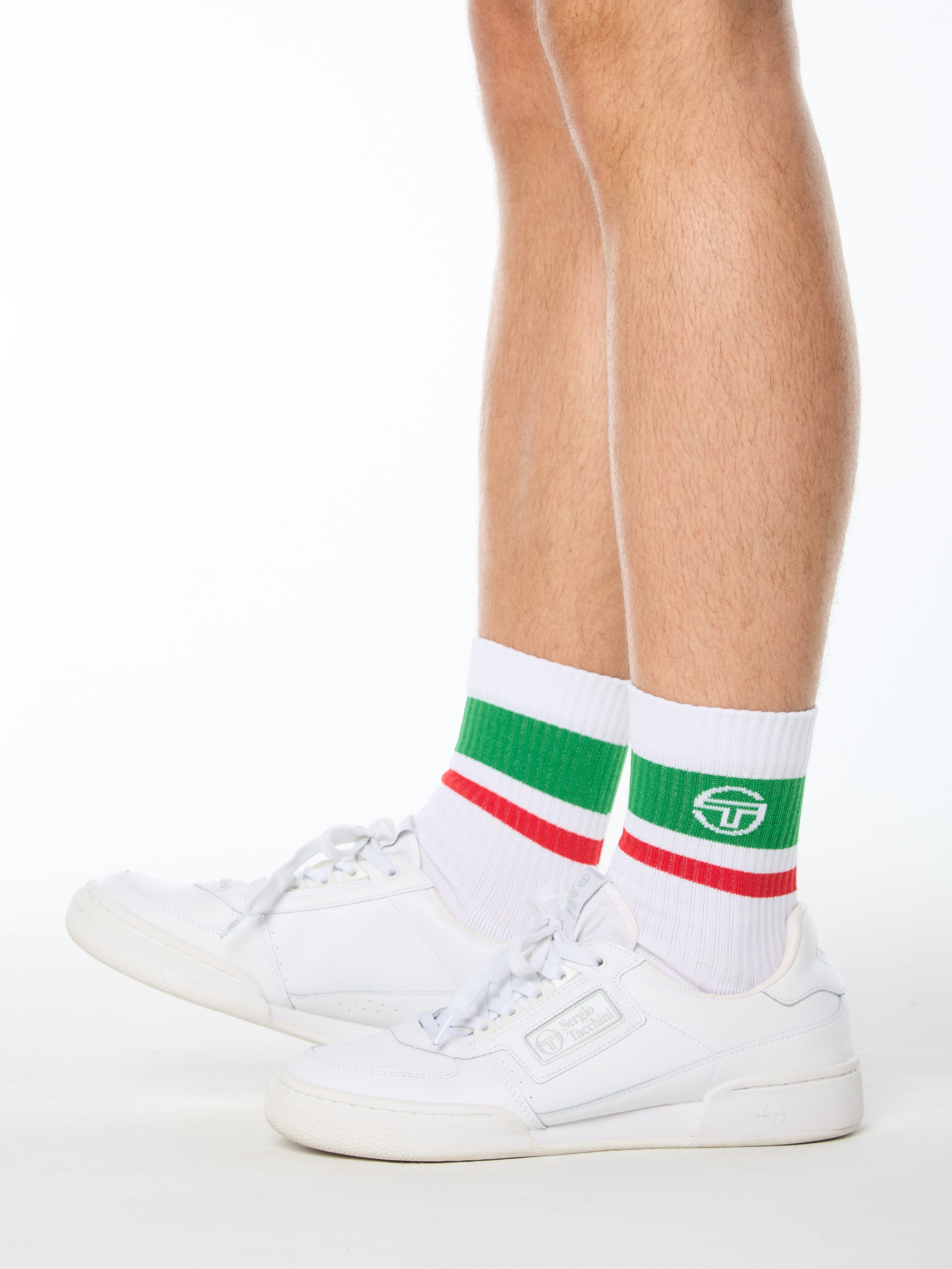 Man wearing white socks with green and red stripes.