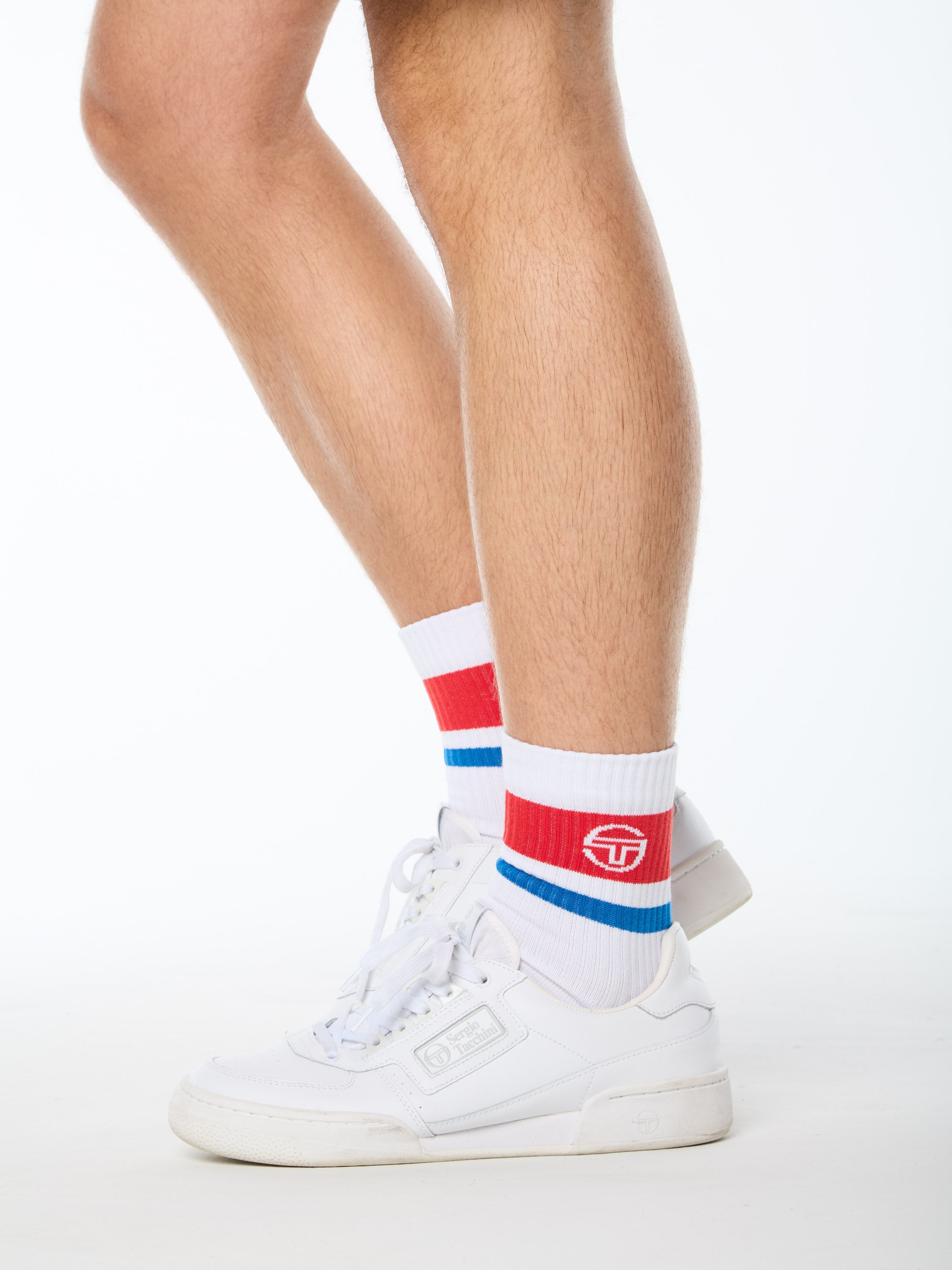 Man wearing white socks with red and  blue stripes.