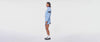 Woman turning around in a circle showing off the baby blue track jacket and matching skirt that she's wearing.